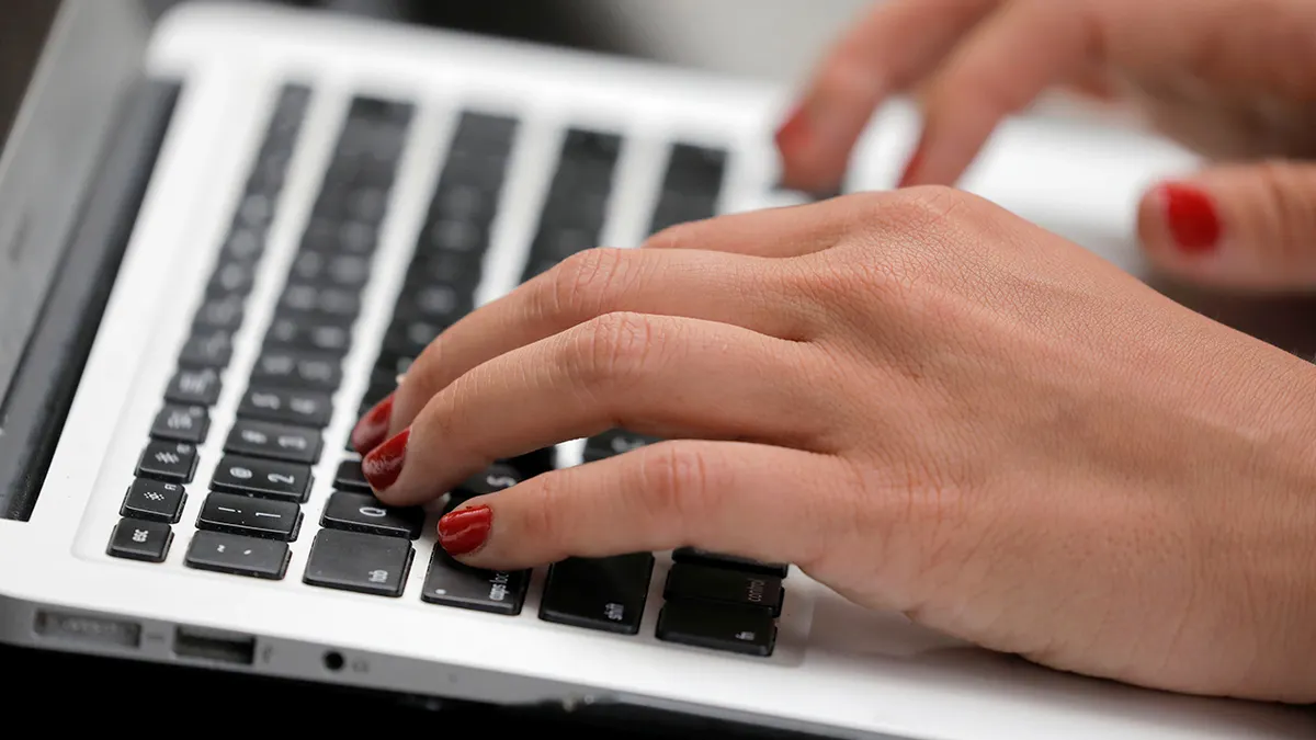 Woman Types on Laptop Computer
